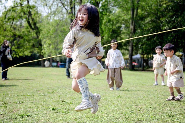 "愉快的亲子互动：孩子们在树荫下的运动会，每个动作都像极了一幅美丽的画"